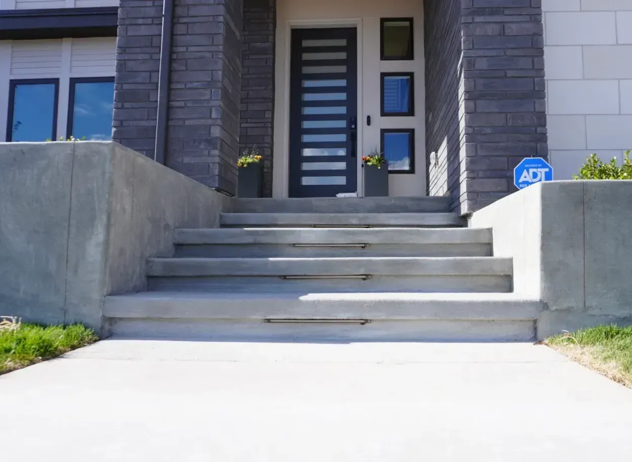 Concrete steps leading up to a modern home's front door.
