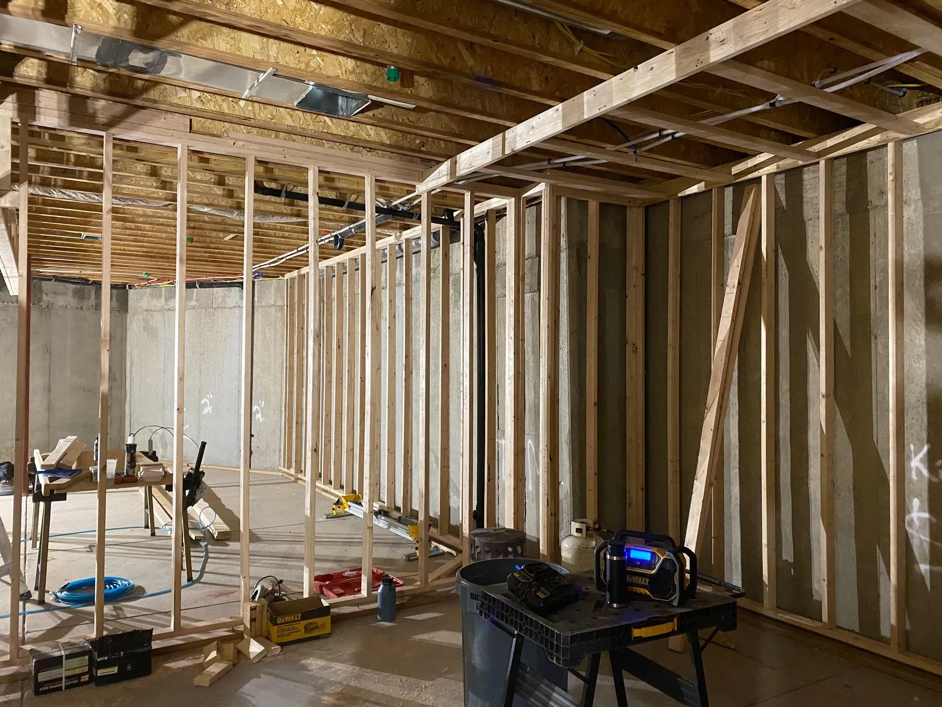 Interior view of a basement under construction with wooden frames for walls and ceiling.