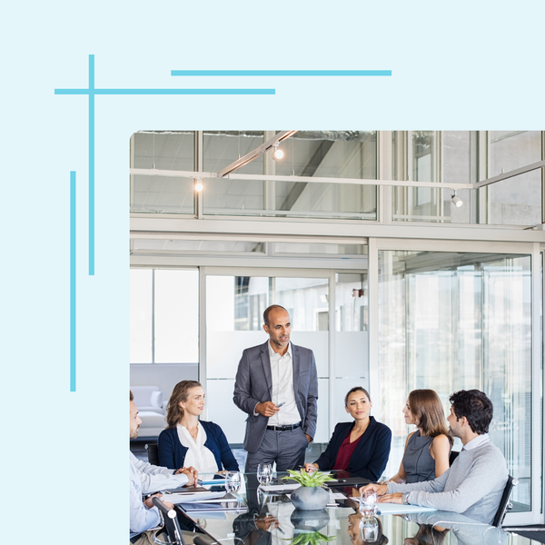 A man is giving a presentation to a group of people sitting around a table.