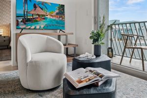 A living room with a chair , table , and television.