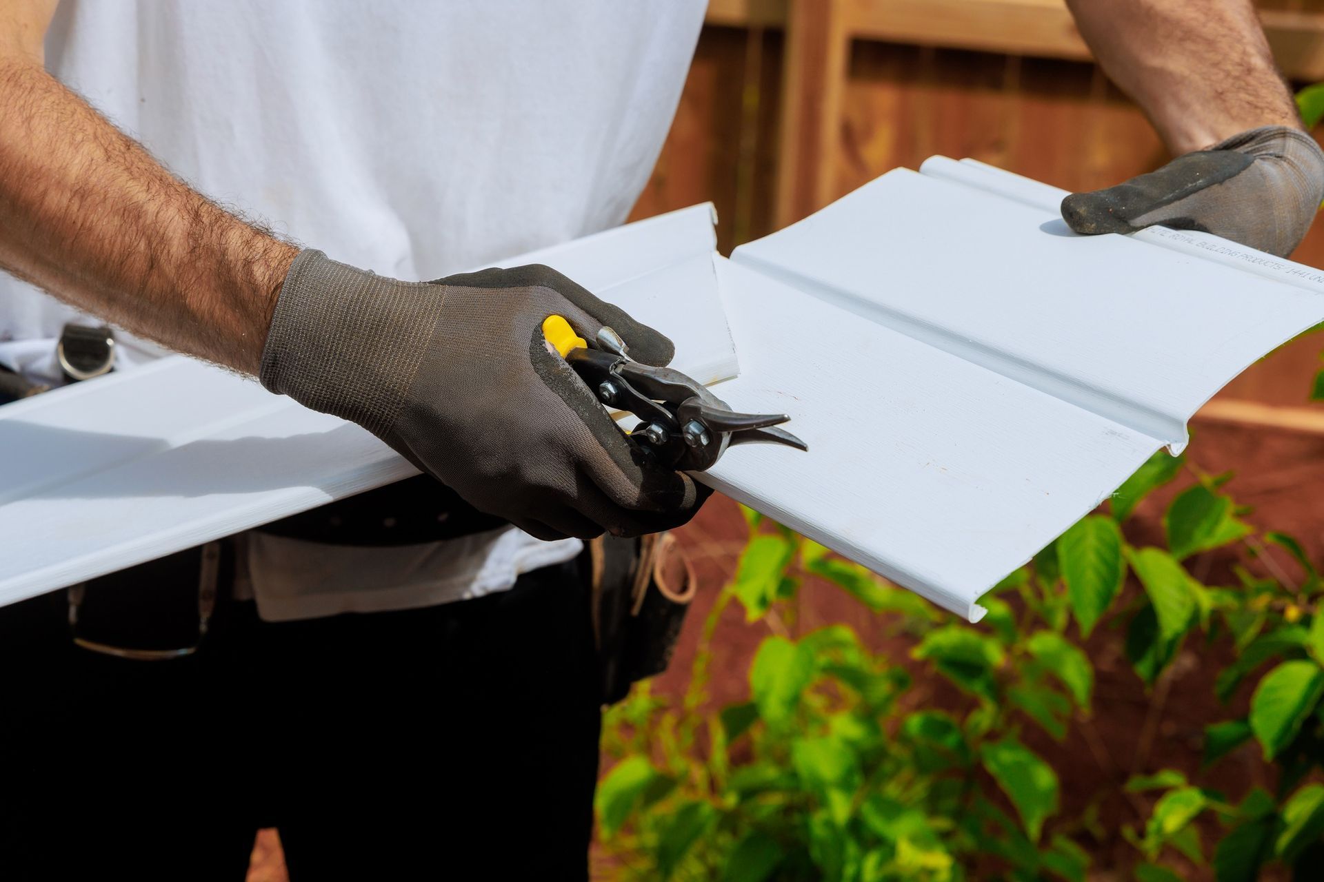 A close-up view of a house undergoing vinyl siding installation.