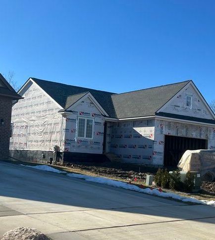 A house is being built in a residential area on a sunny day.
