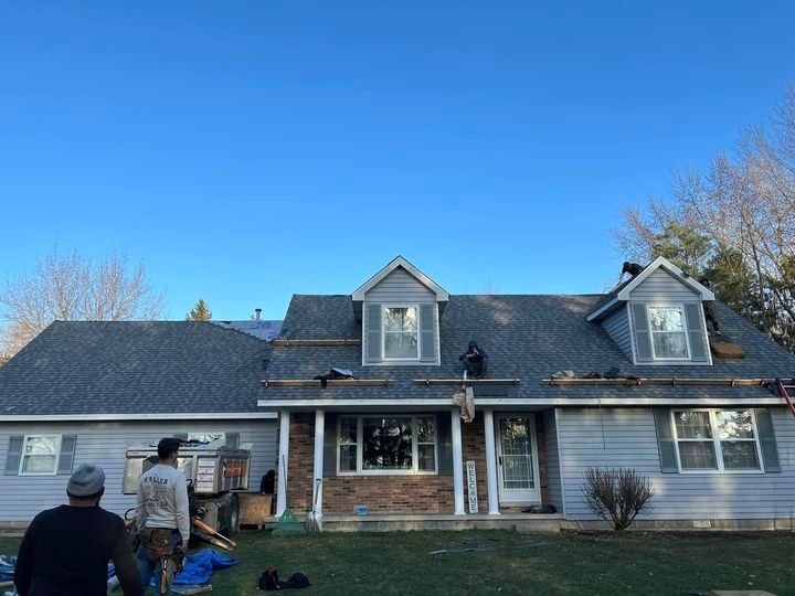 A man is working on the roof of a house.