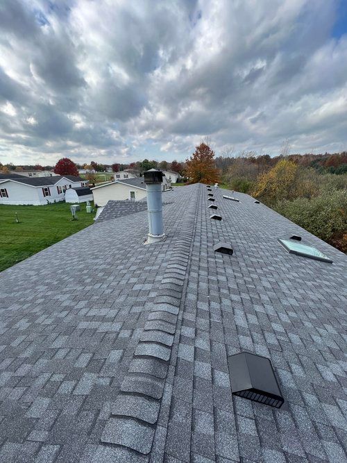 The roof of a house with a chimney on it and a skylight.