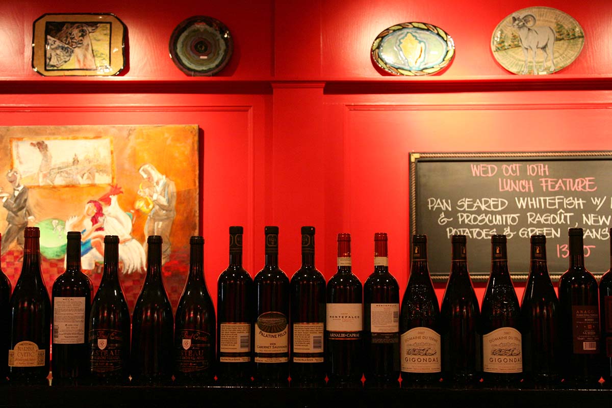 many bottles of wine are lined up on a shelf