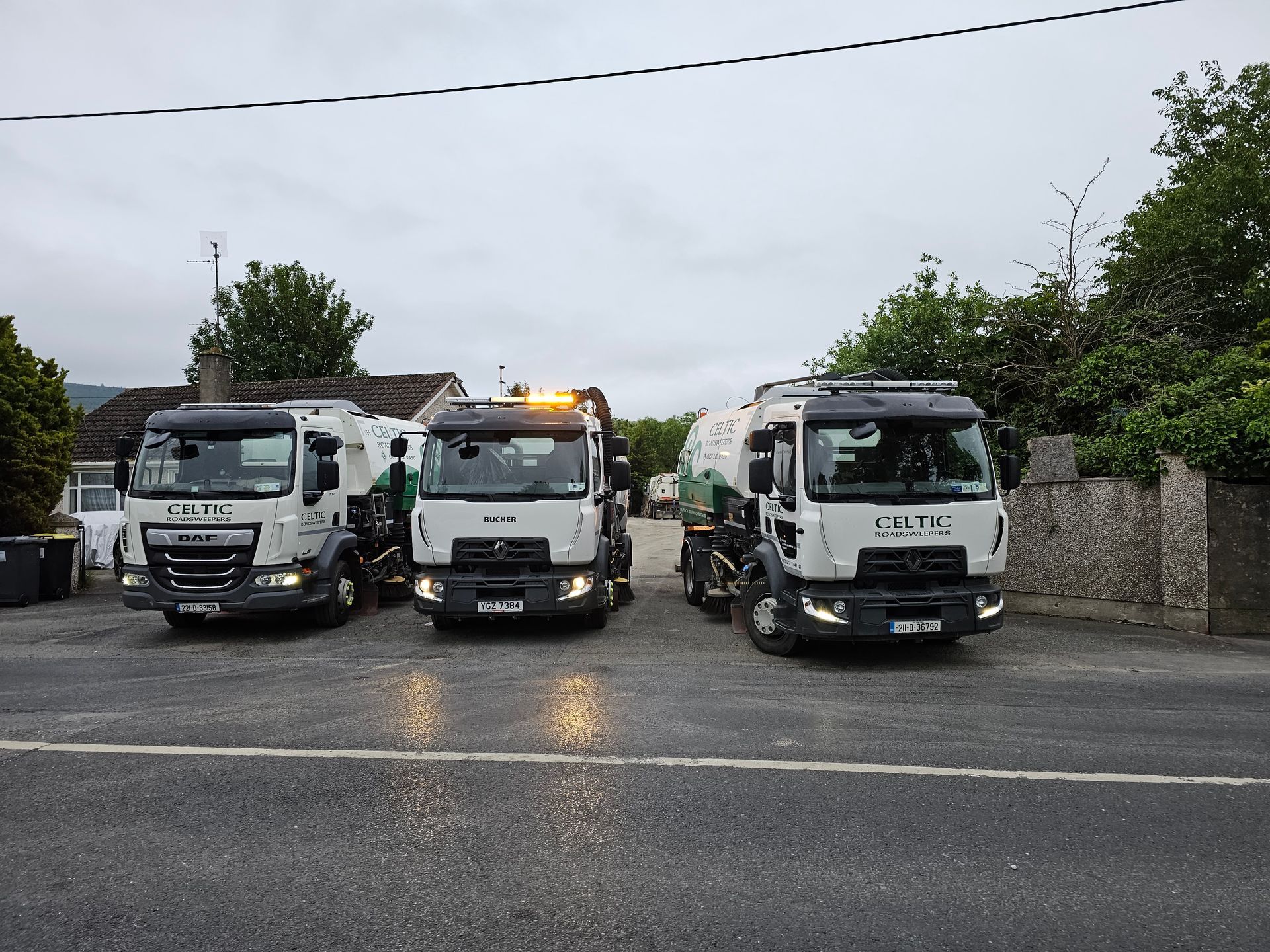 A row of trucks are parked in a parking lot.