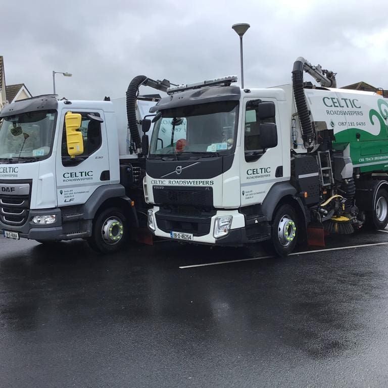 Three celtic trucks are parked in a parking lot