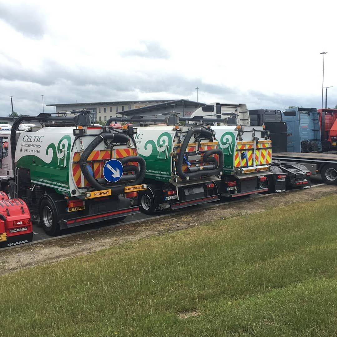 A row of trucks parked next to each other in a grassy field.