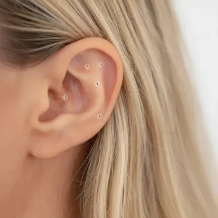 Ear with showing ear seeds placed using the NADA 5np protocol. Blonde hair visible.