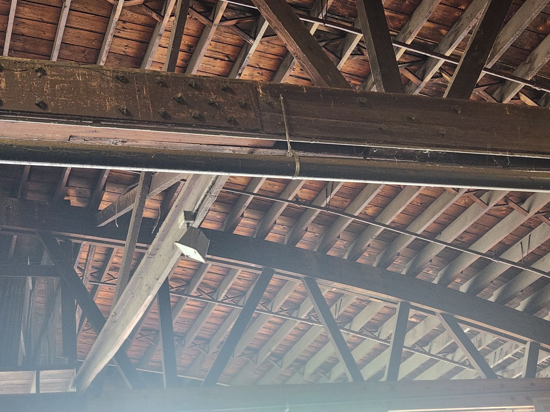 An empty building with wooden beams, a school bus visible in the background, located in Chicago, IL
