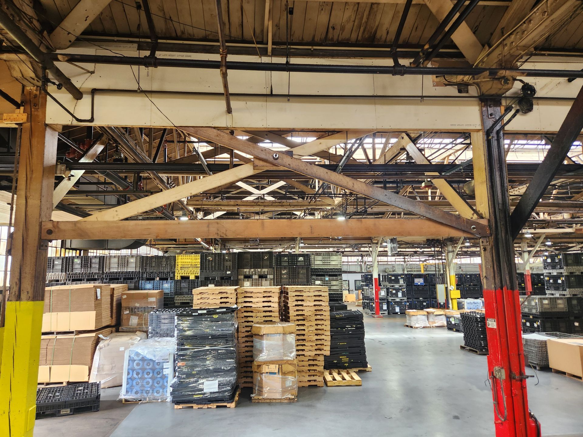 The ceiling of a building under construction is made of wood and metal.