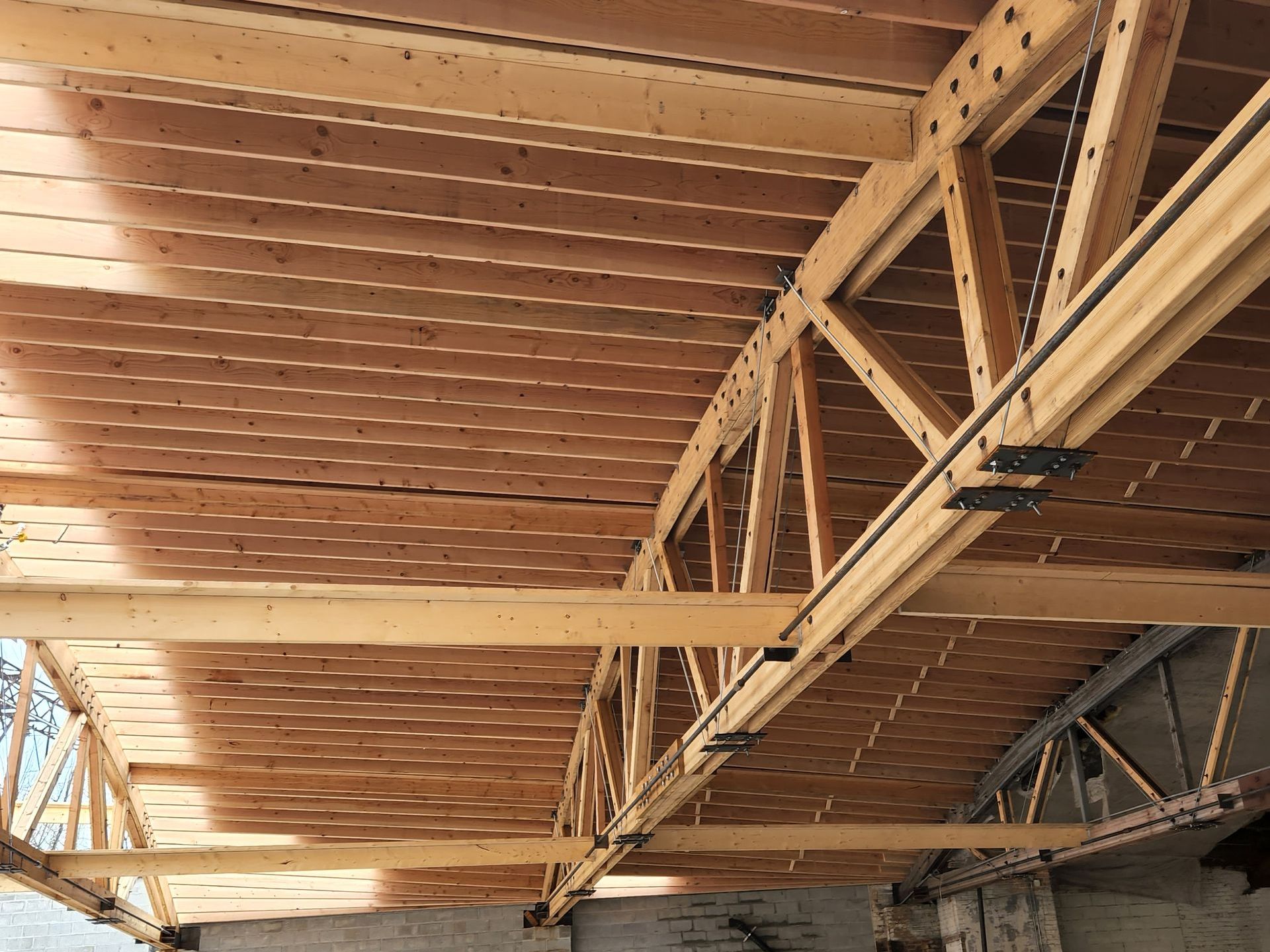 The ceiling of a building under construction is made of wood and metal.