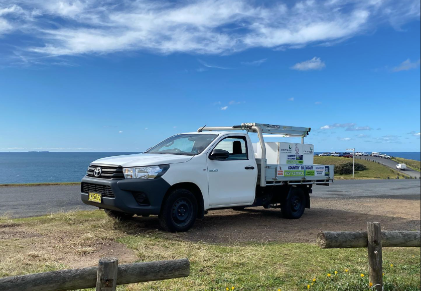 A Man in a Protective Suit is Spraying a Room With a Sprayer — Country to Coast Pest Control In Sawtell, NSW