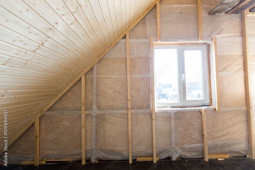 There is a window in the attic of a house under construction.