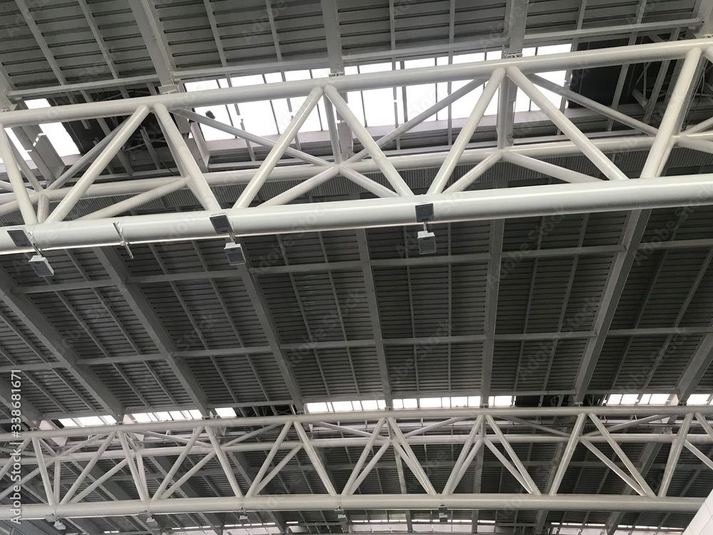 The ceiling of a building with a lot of metal beams.