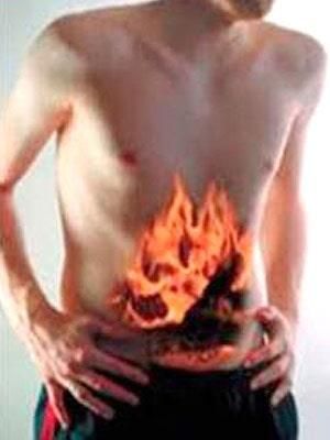 Un hombre sin camisa se sostiene el estómago del cual salen llamas.