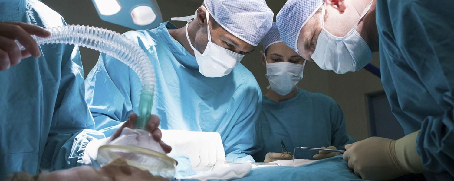 Un grupo de cirujanos está operando a un paciente en un quirófano.