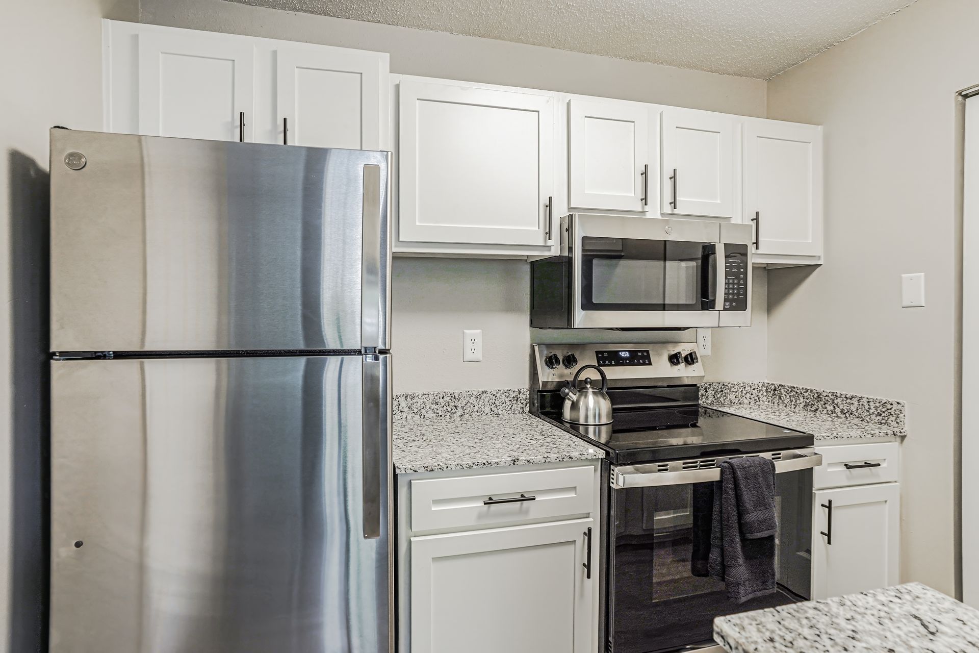 A blue-painted surface with white shapes, framed by grass, hedges, and buildings in a daylight setting.