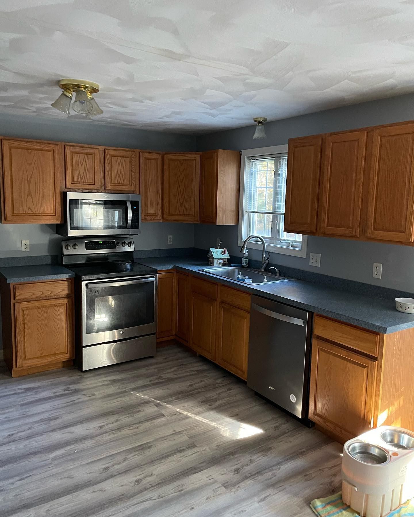 Kitchen with wooden cabinets, stainless steel appliances, and gray countertops.
