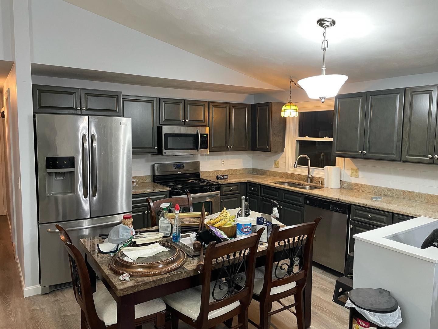 Kitchen with dark gray cabinets, stainless steel appliances, and a dining table.