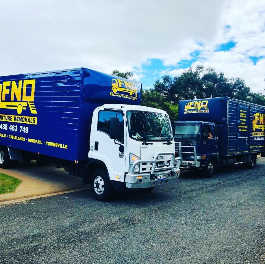 Two Fnq Moving Trucks Are Parked on the Side of the Road — FNQ Furniture Removals in Innisfail, QLD