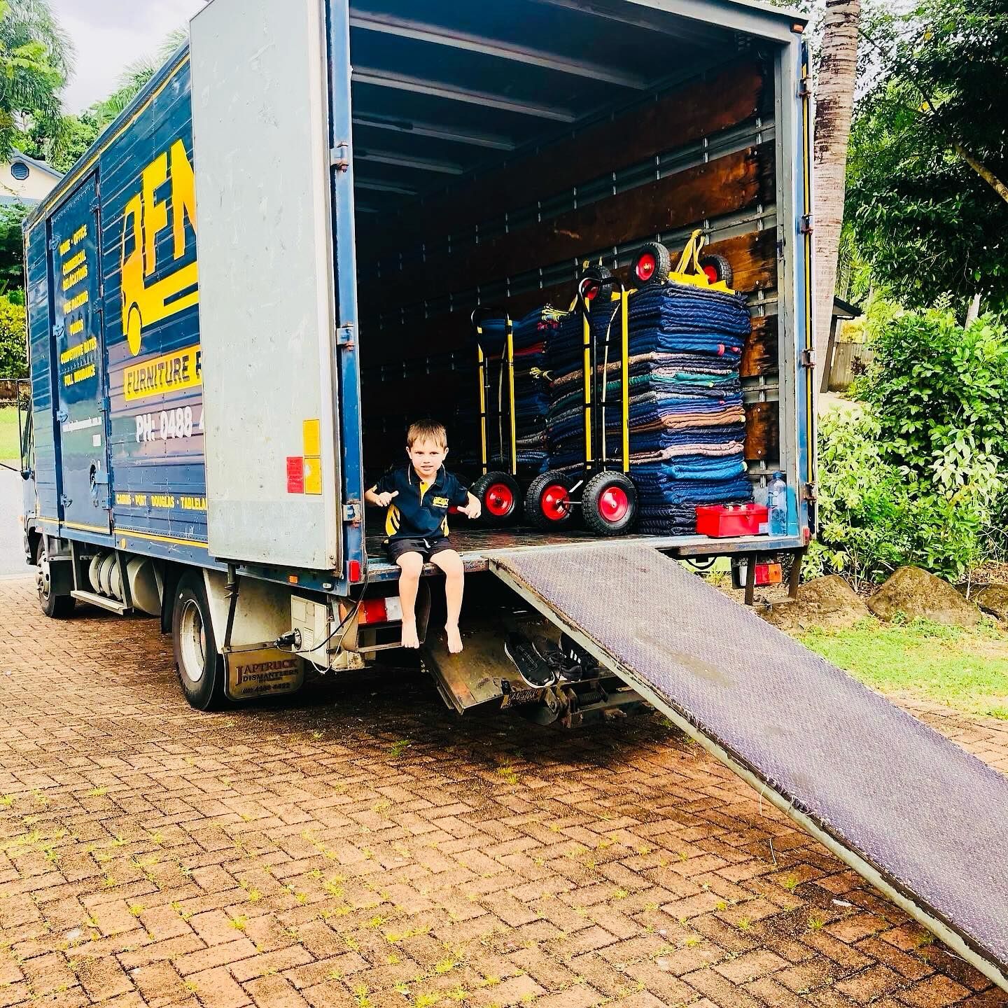 A Chair Wrapped in Plastic is Sitting in a Room Surrounded by Cardboard Boxes — FNQ Furniture Removals in Stratford, QLD
