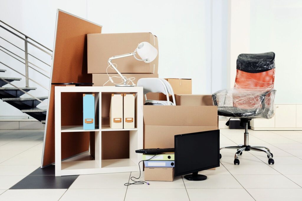 A room filled with boxes , furniture , and a chair — FNQ Furniture Removals in Ingham, QLD
