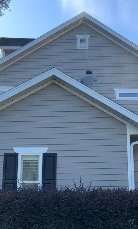 A man is painting the side of a house.