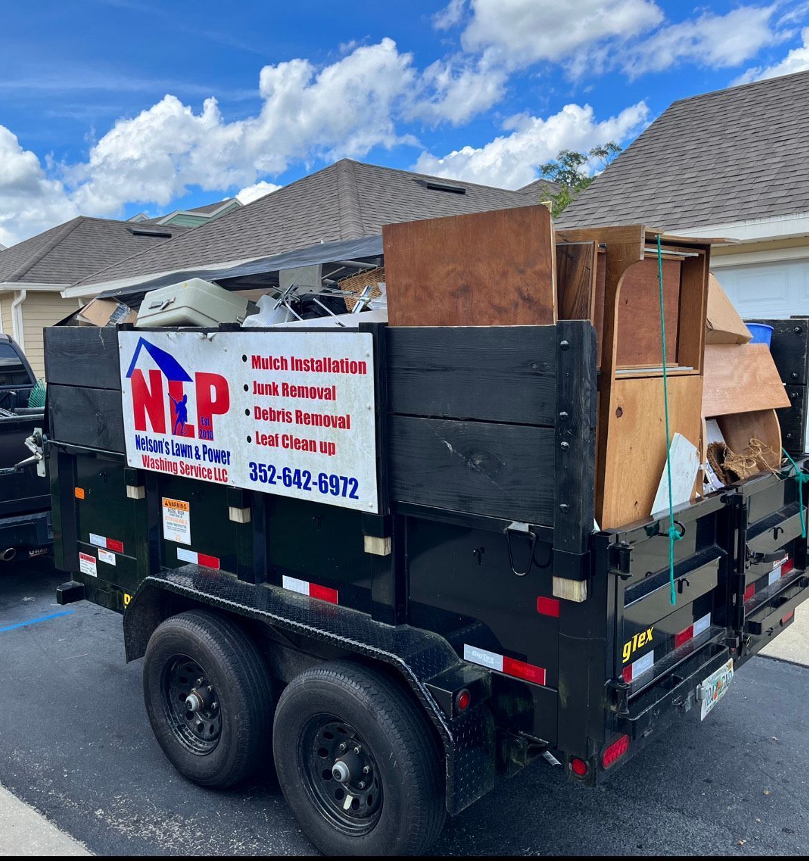 A dumpster with the word nlp on it is parked in front of a house