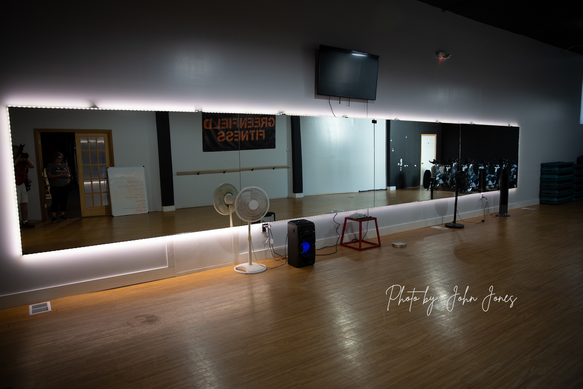 A dance studio with a large mirror and a sign that says ' it 's a workout ' on it
