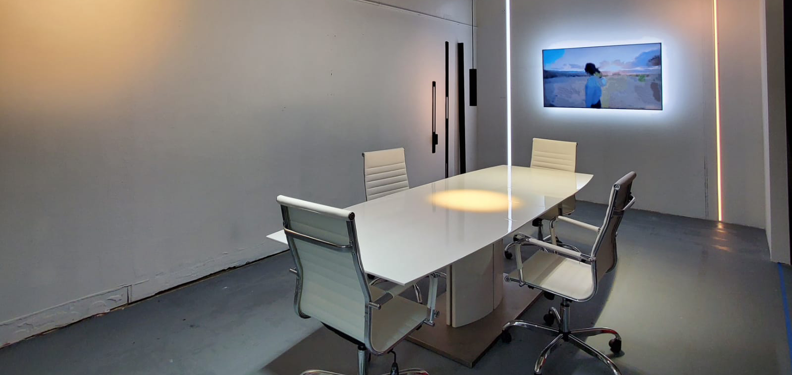 A conference room with a long white table and chairs.