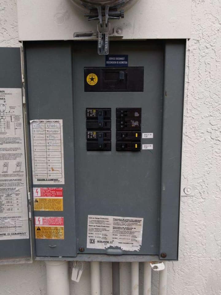 A electrical box is sitting on a white wall.