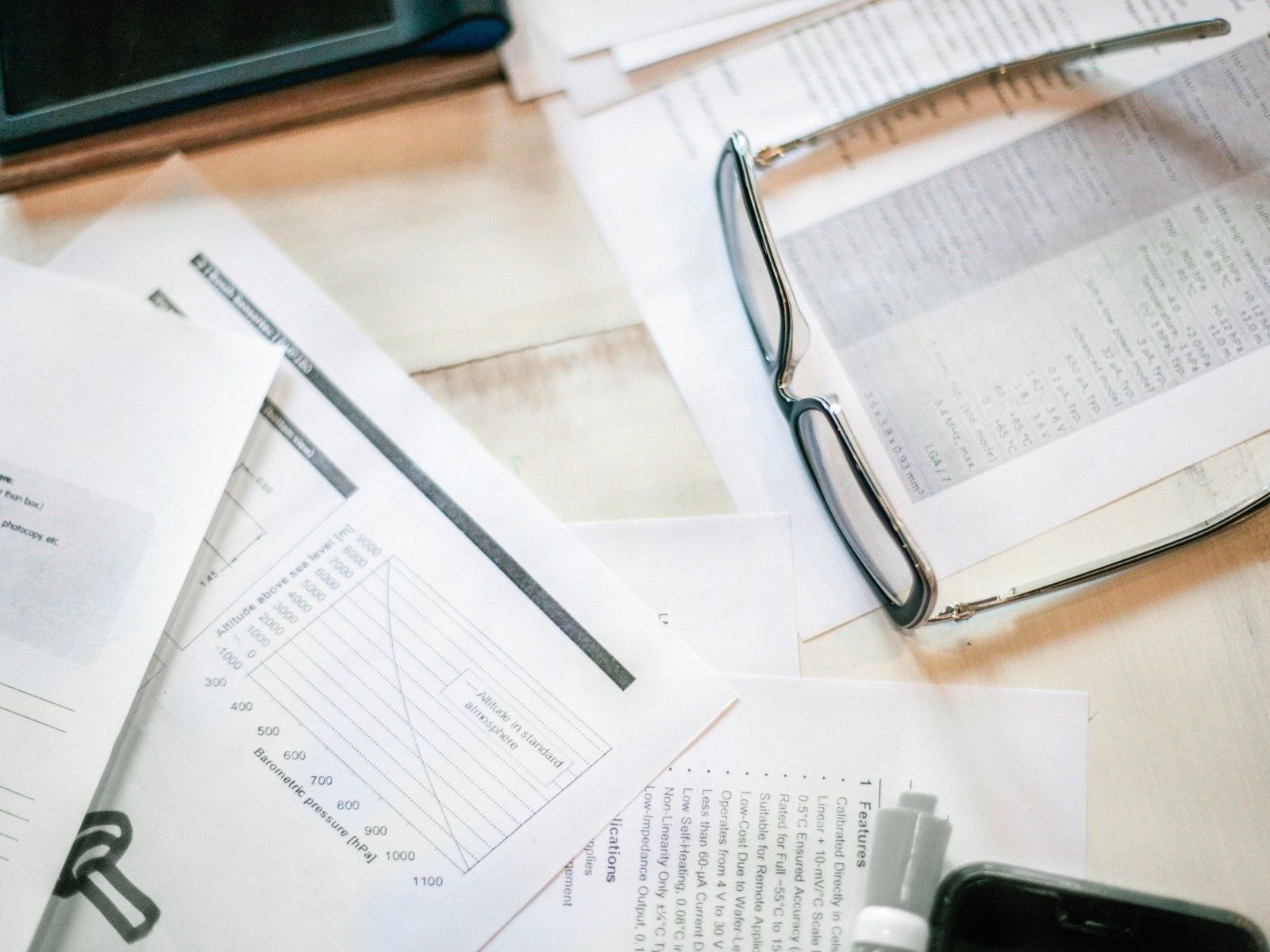 stack of documents on desk with glasses