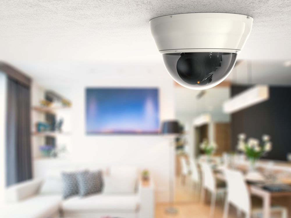 A Security Camera Is Hanging From The Ceiling Of A Living Room — On Guard Security & Communications In Wallsend, NSW