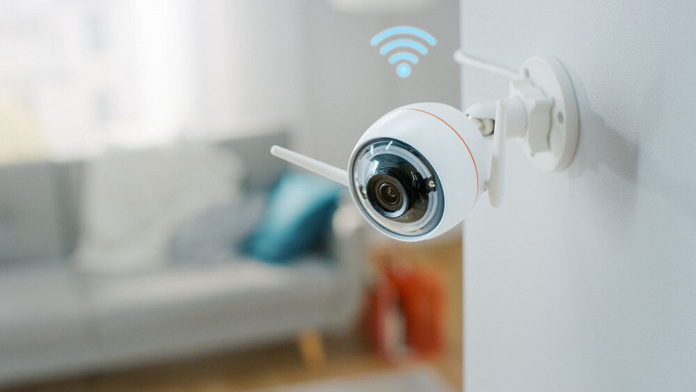 Security camera mounted on a brick wall, overlooking a backyard — On Guard Security & Communications In Central Coast, NSW