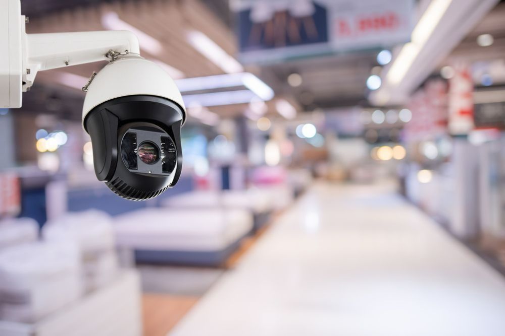 A Security Camera Is Hanging From The Ceiling In A Store — On Guard Security & Communications In Wallsend, NSW