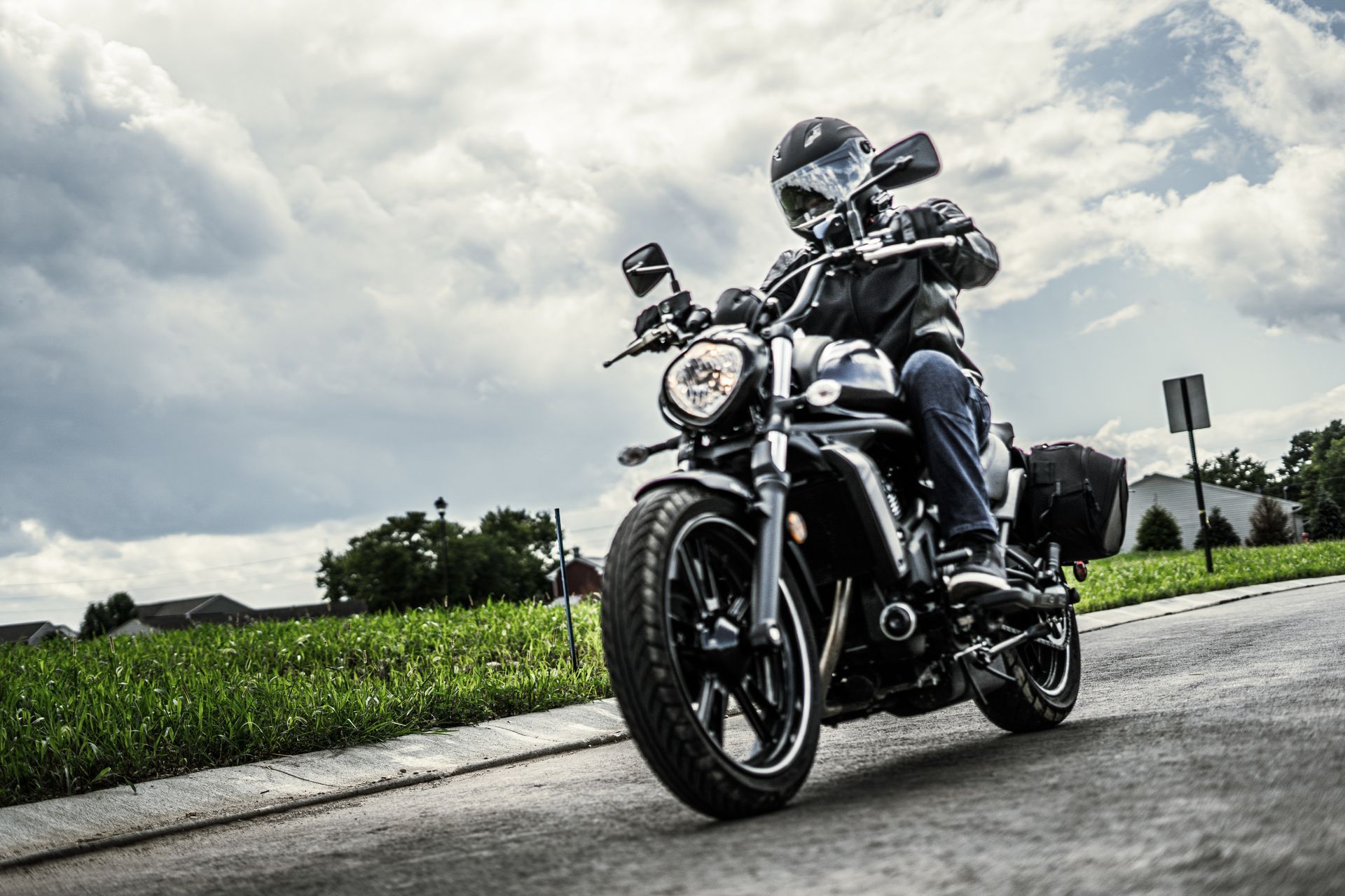 A man is riding a motorcycle down a road.