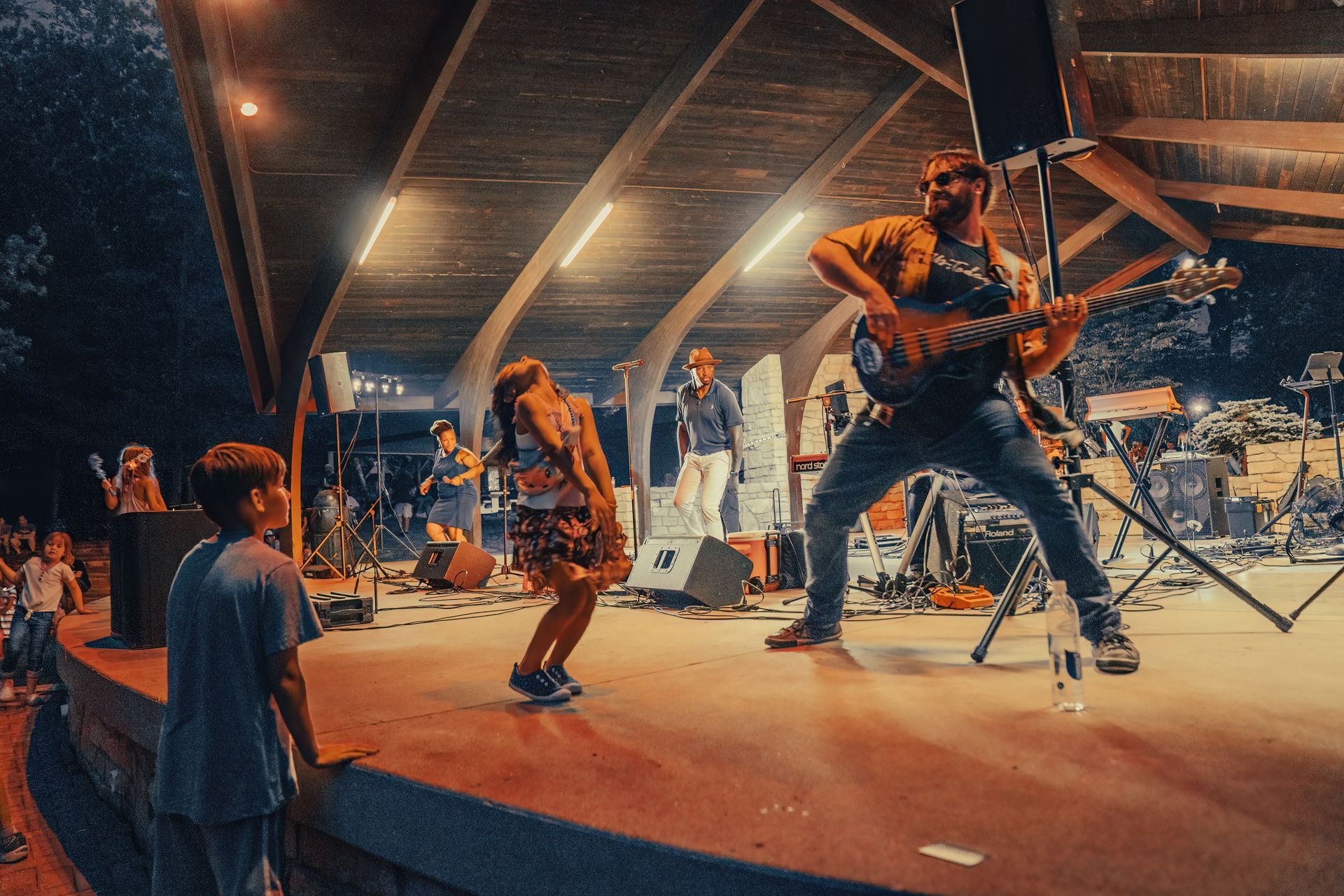 A man is playing a guitar on a stage in front of a crowd of people.