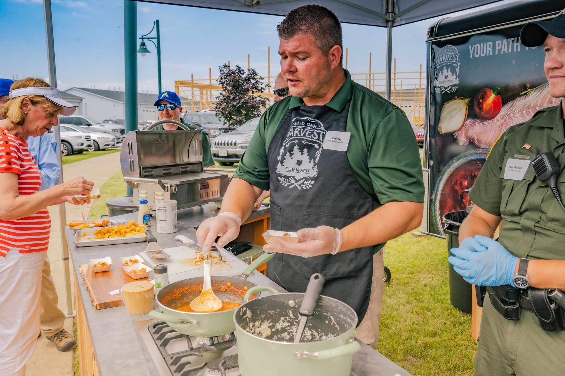A man in an apron is preparing food at a table.
