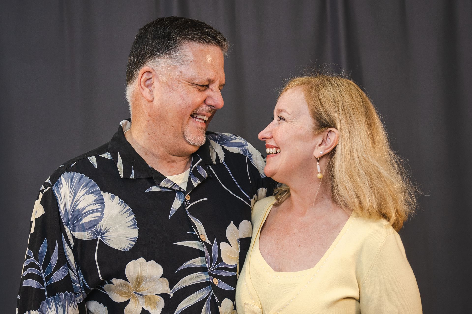 A man and a woman are standing next to each other and smiling.