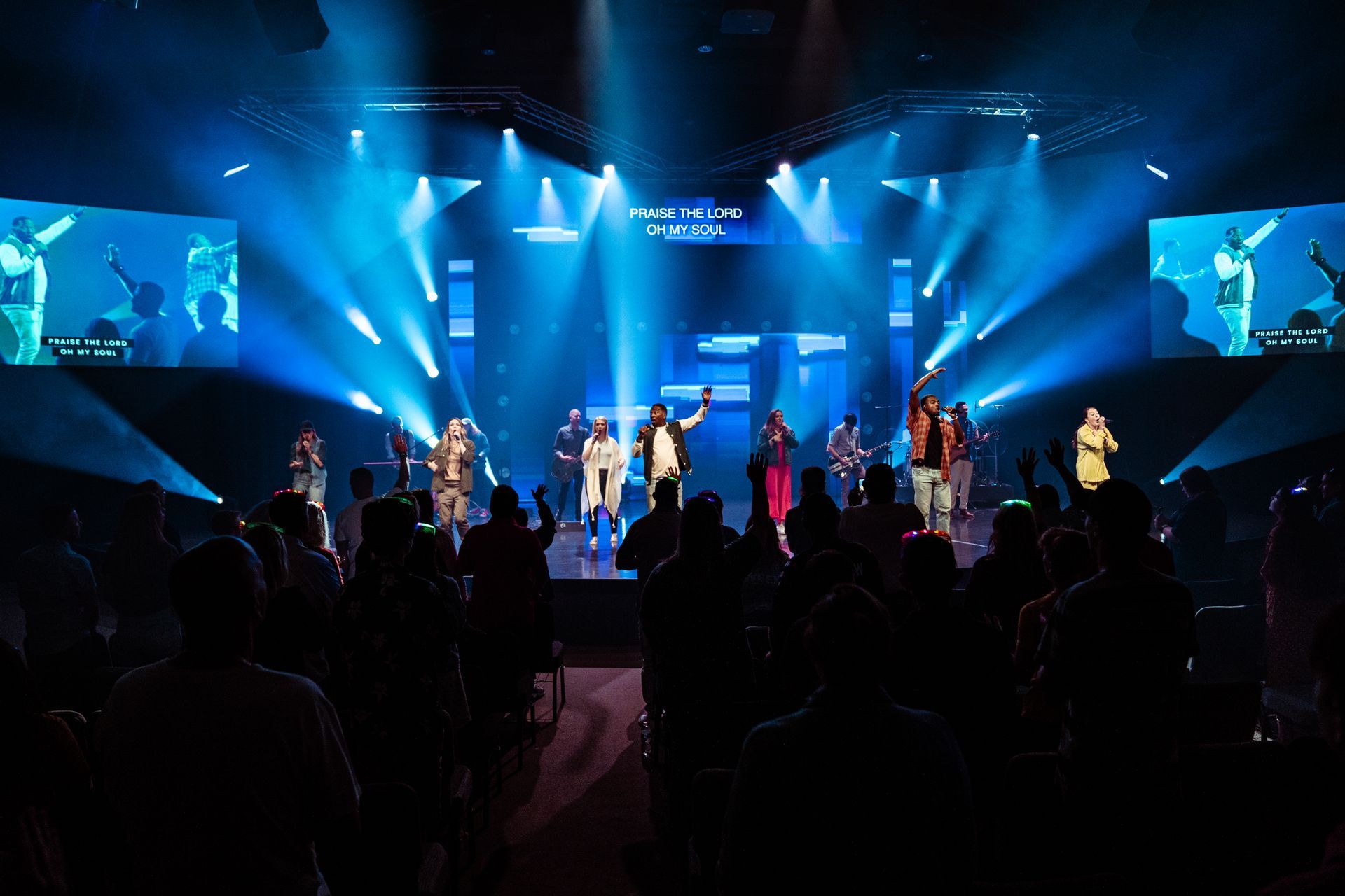 A group of people are standing on a stage in front of a crowd.