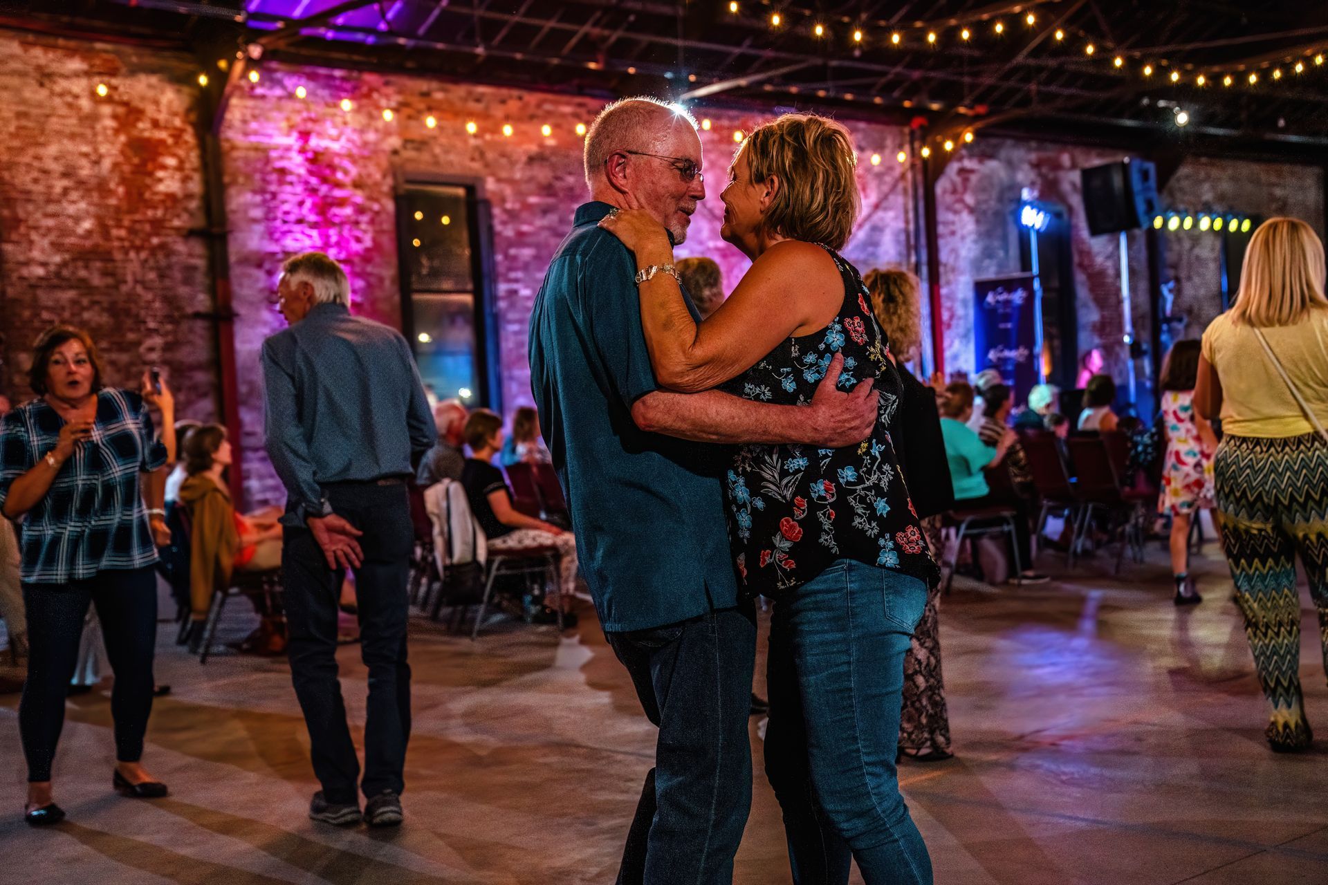 A man and a woman are dancing together in a crowded room.