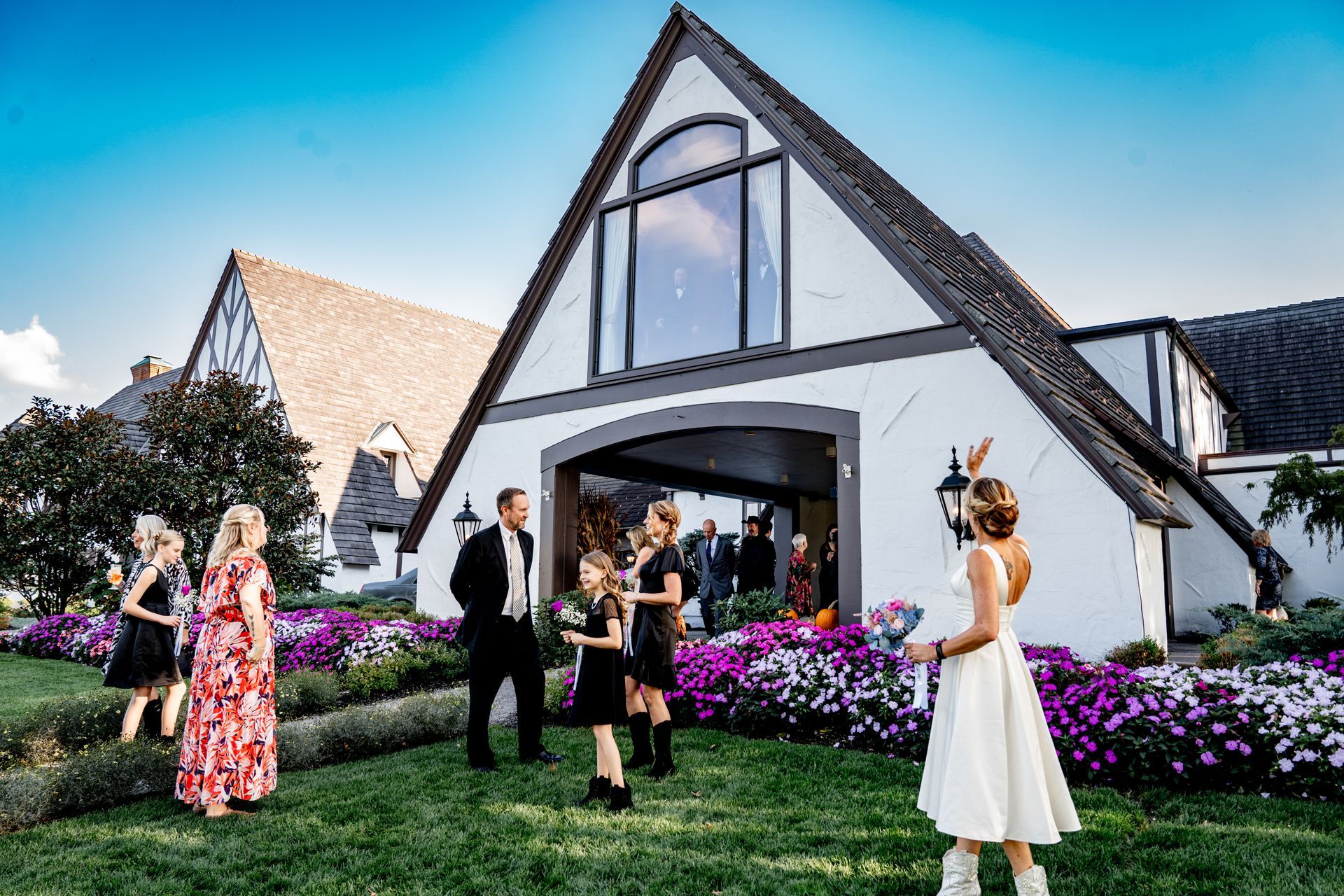 A group of people are standing in front of a large white building.