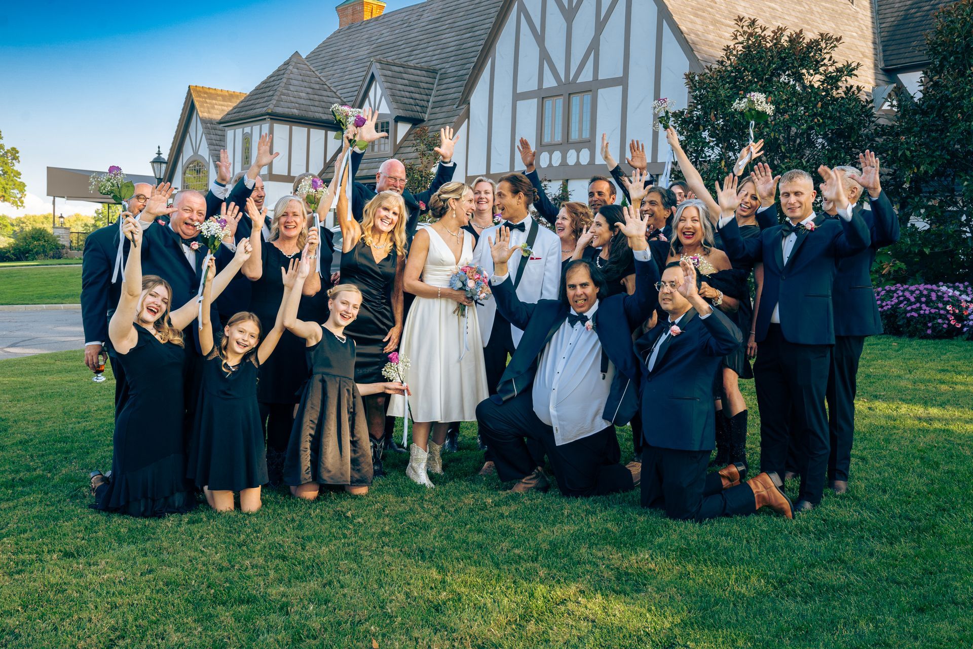 A large group of people are posing for a picture in front of a house.
