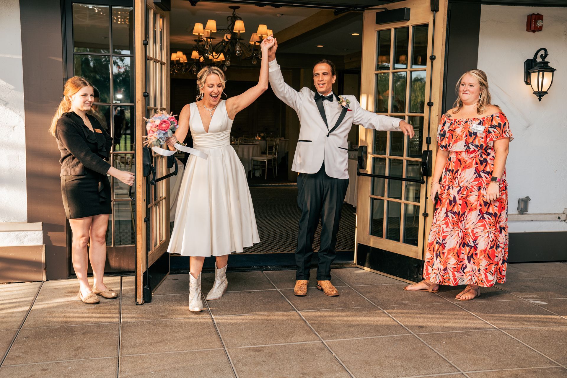 A bride and groom are holding hands while standing in front of a building.