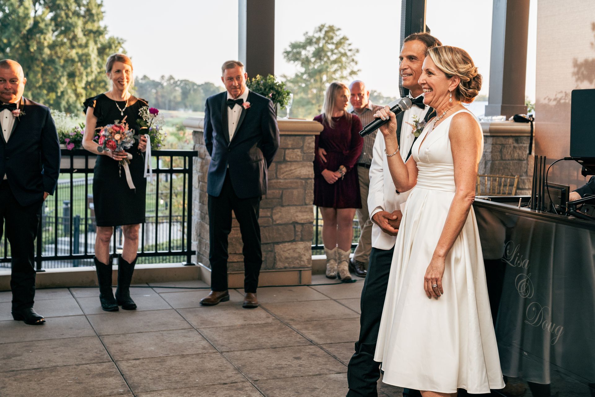 A bride and groom are giving a speech at their wedding reception.