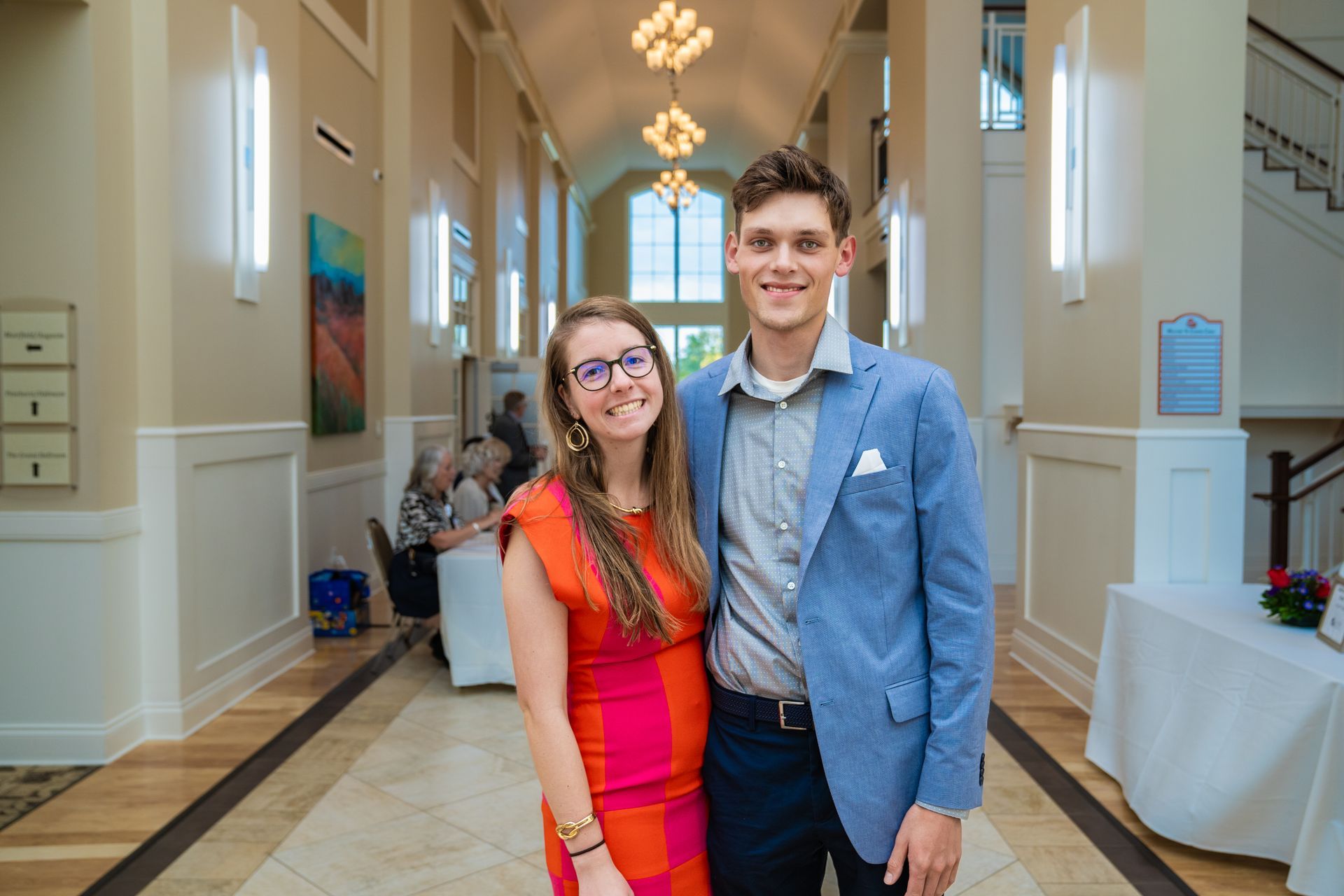 A man and a woman are posing for a picture in a hallway.