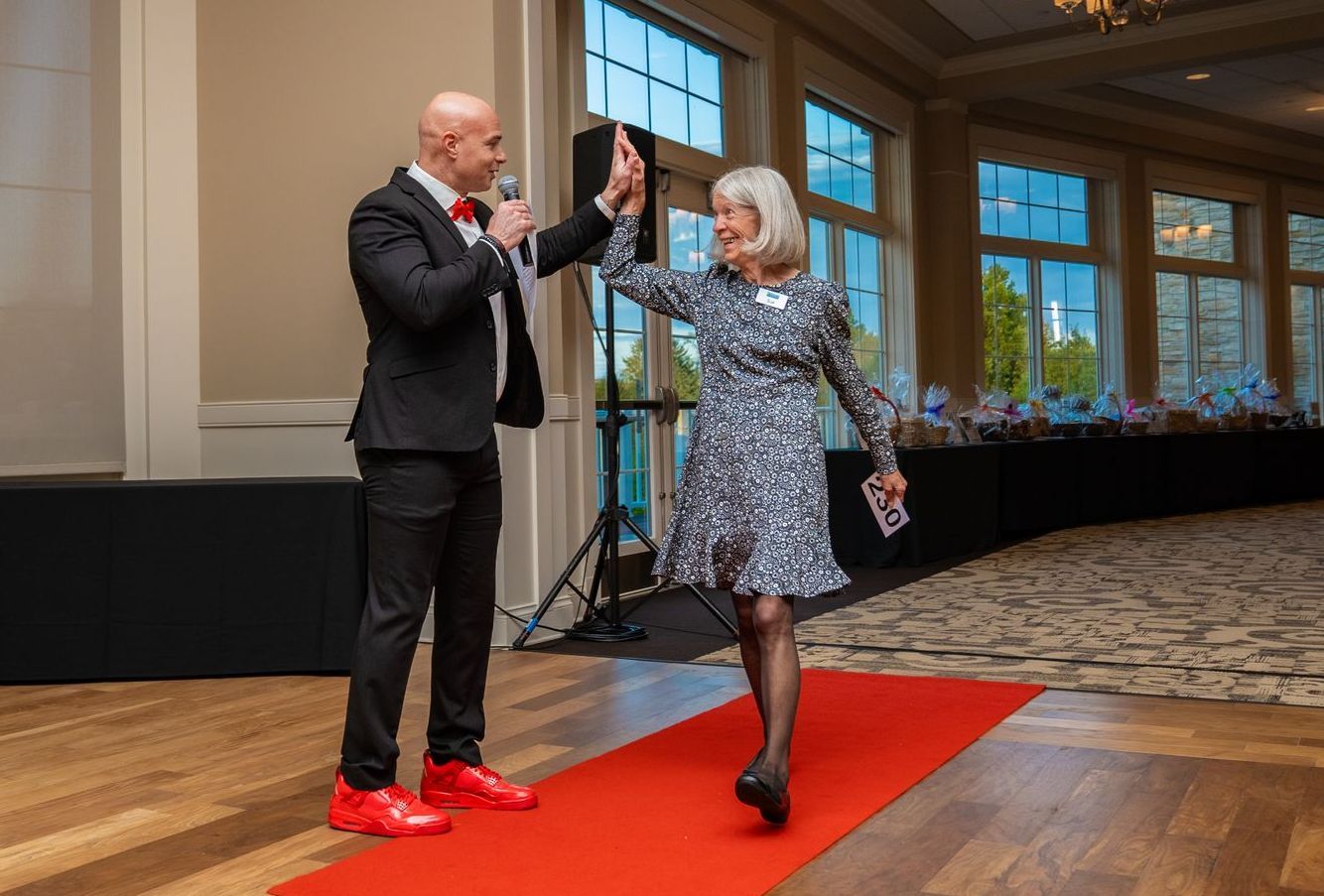 A man is giving a high five to a woman on a red carpet.