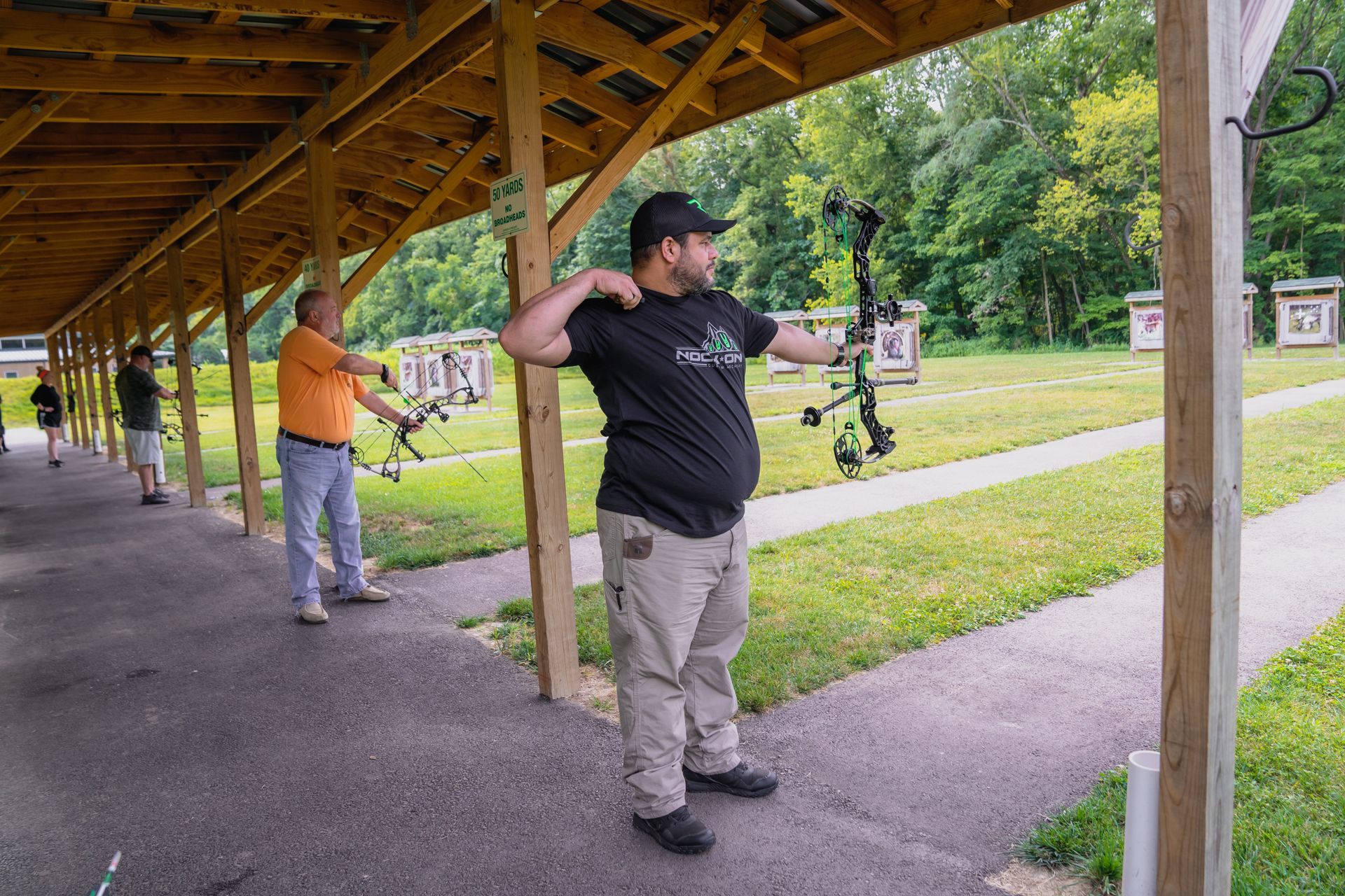 men shooting bows at targets