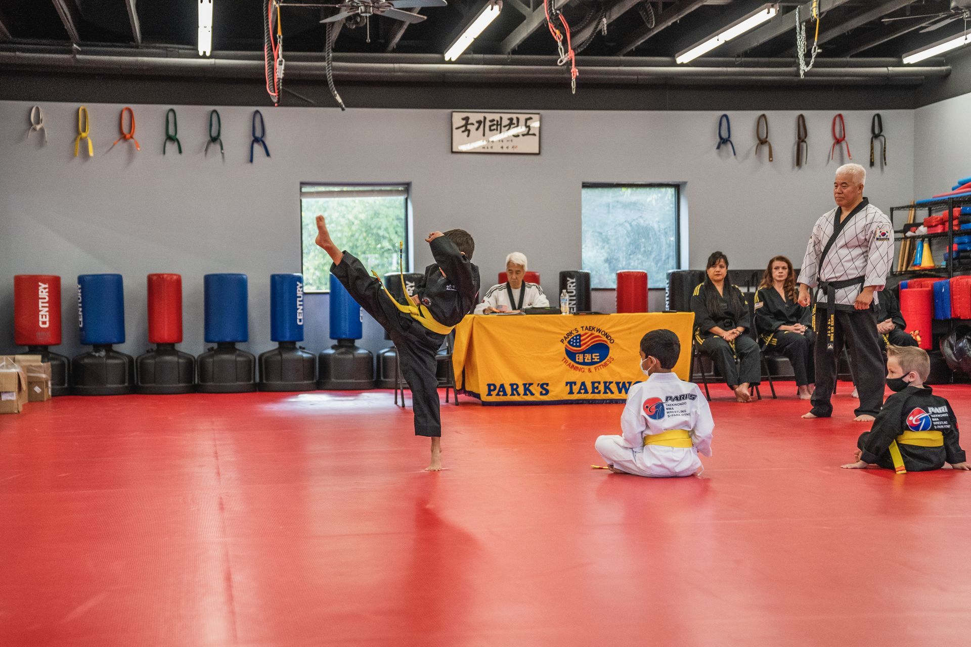 A group of children are practicing martial arts in a gym.